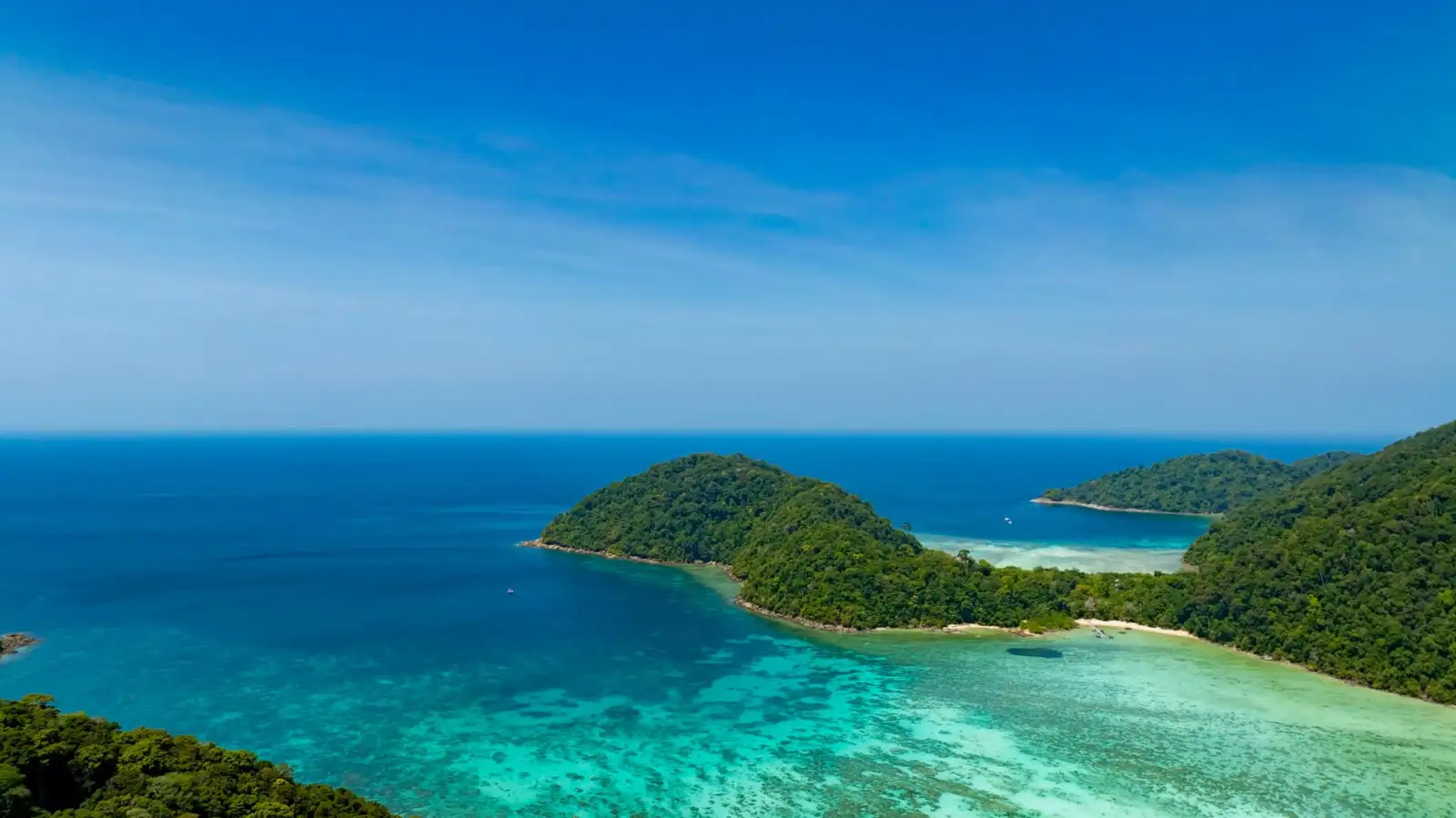 Green islands surrounded by clear turquoise and blue ocean